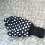 Outside view of thrummed mitten, dark colour with white motifs.