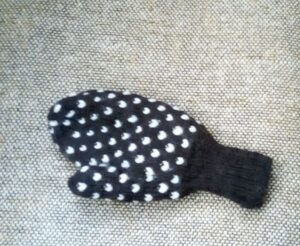 Outside view of thrummed mitten, dark colour with white motifs.