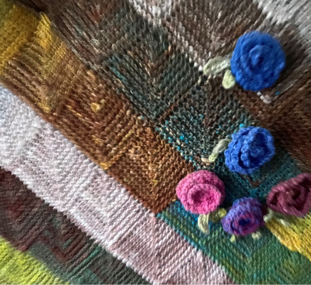 Patchwork knitting embellished with flowers
