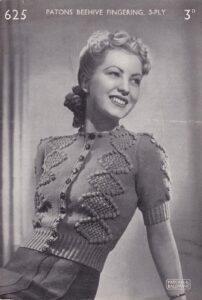Cover of Patons leaflet 625 (3d) showing lady wearing knitted round-neck cardigan with diamond lace panels bordered with bobbles on each side of front and on short set-in sleeves.
