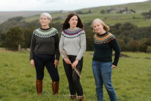 Photo of three members of the Stodley fair isle jumpers group wearing fair isle jumpers.